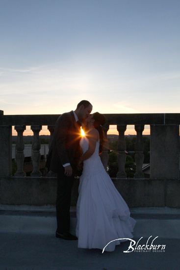 Bride and Groom silhouette kissing with sunflare on rooftop of Franklin Plaza NY