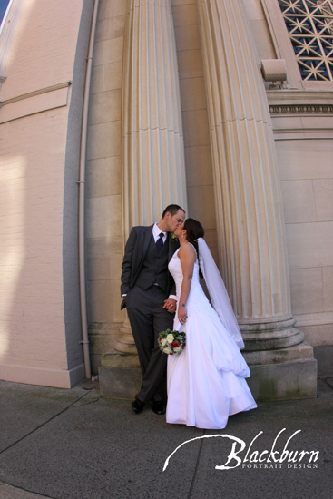 Bride and Groom kissing next to columns outside of Franklin Plaza in Troy