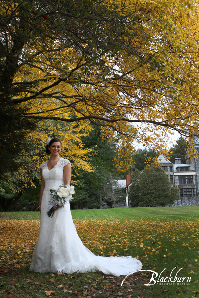 Bride standing under tree with fall foliage at Yaddo in Saratoga NY