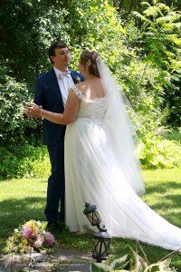 Marissa and Nate dancing in wedding attire in garden of Mansion Saratoga.